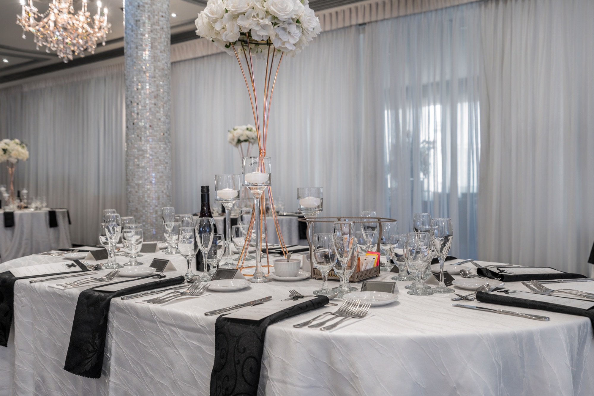 Table de réception dressée avec fleurs blanches et verrerie